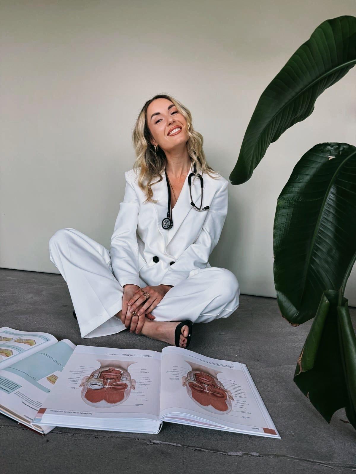 Katharina Haas, lächelnd mit Stethoskop und Anatomiebuch